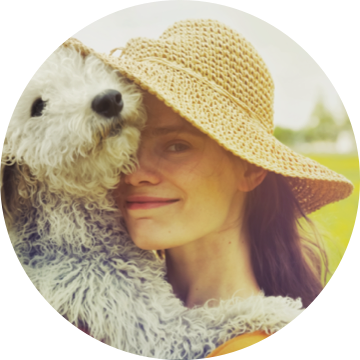 Woman wearing a hat holding a dog